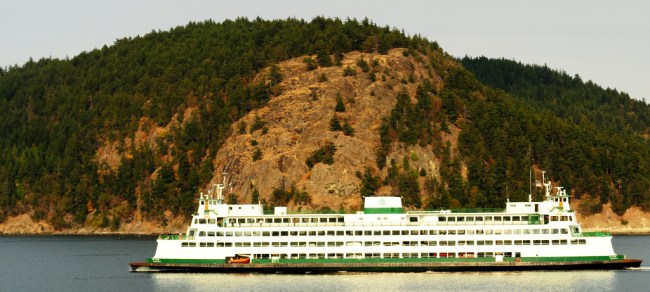 A ferry passes rock outcrops in the San Juan Islands