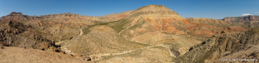 A desert scene with colorful cliffs and sparse vegetation.