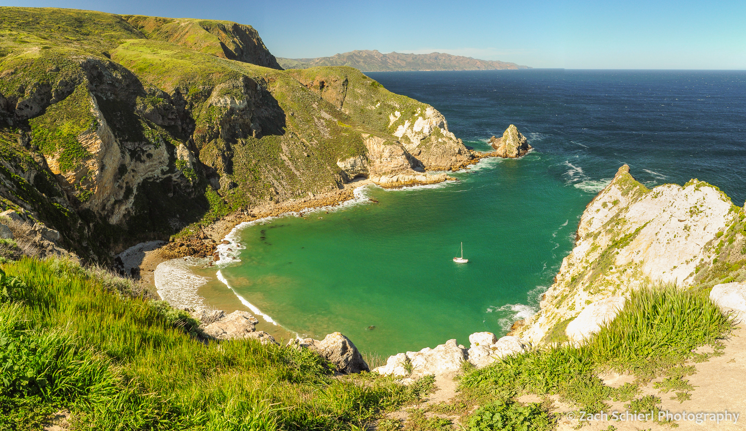 A small ocean inlet with blue-green water along a rugged coastline