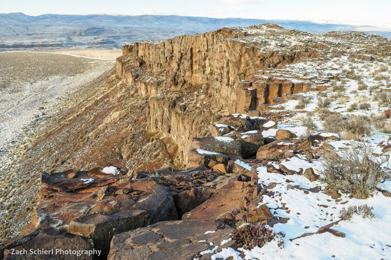 A cliff of basalt with patches of snow