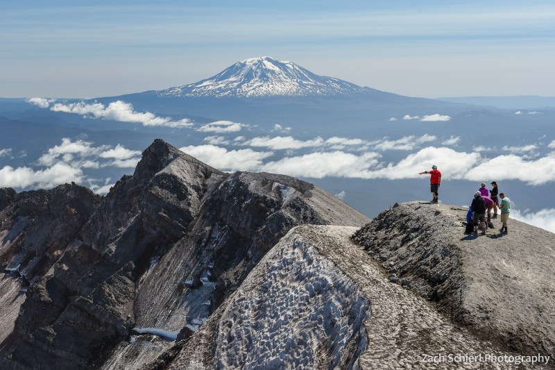 View of rocky and snowy ridgeline with volcanic peak in the background