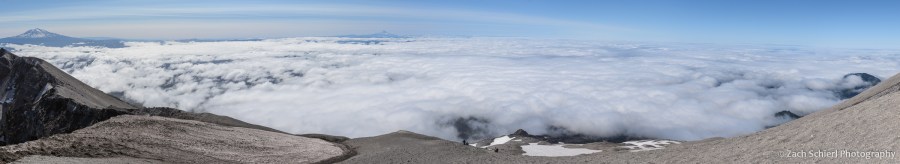 Panorama showing a variety of distant mountains and a low cloud layer