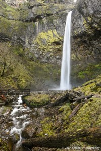 A thin, tall waterfall plunges off of a cliff into a pool.