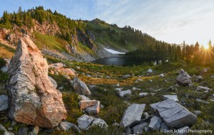 Sunrise light illuminates rocks in an alpine lake basin.