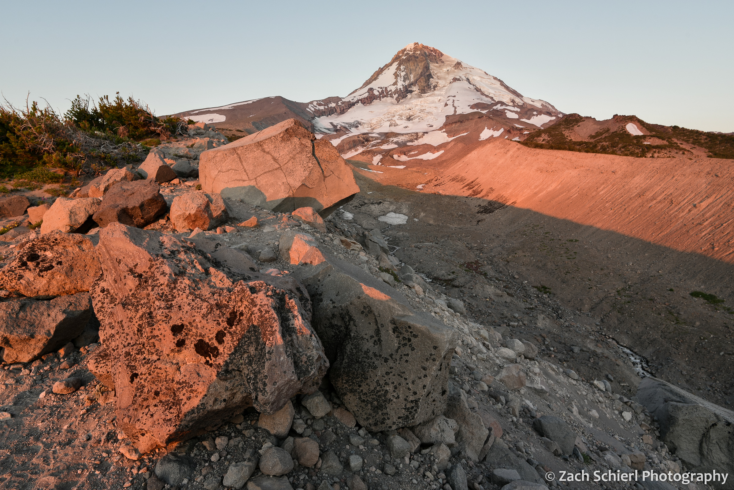 A ridge of rocks and gravel framed a tall snow-capped peak in the background
