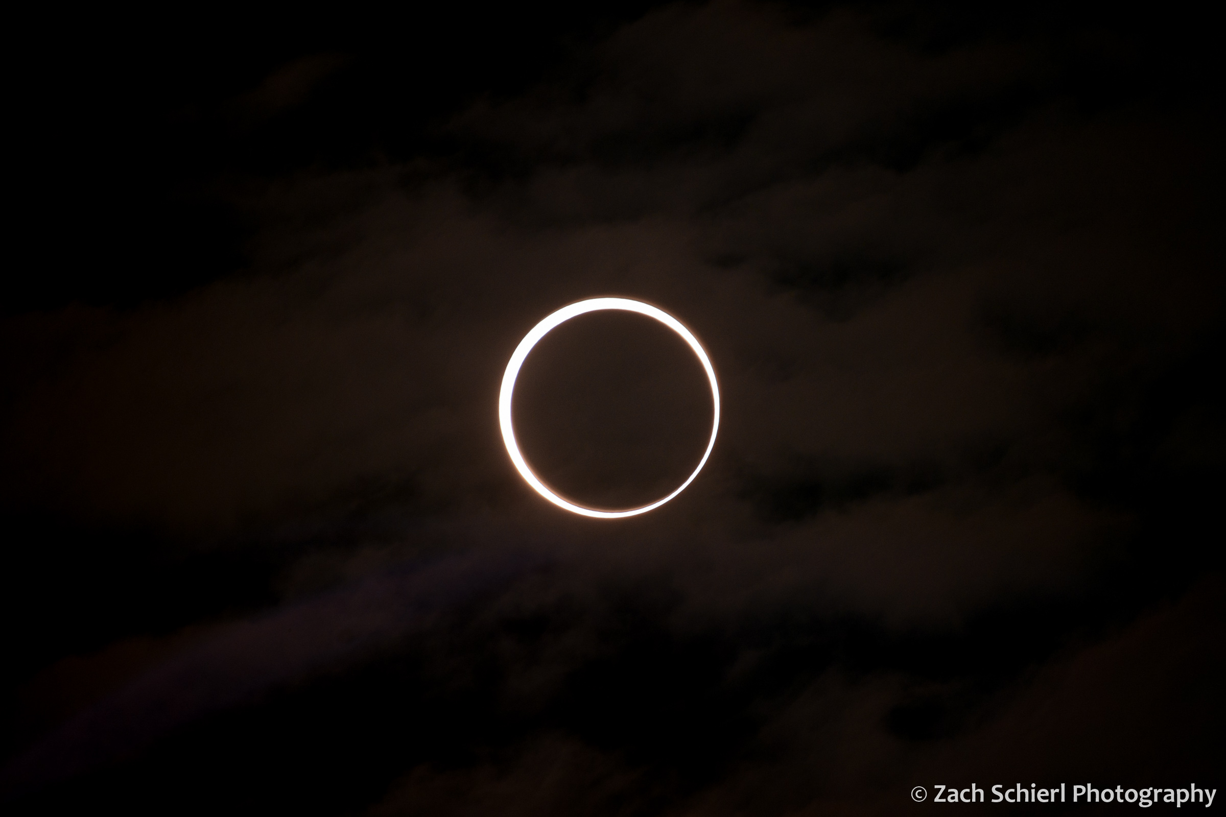 A bright ring of sunlight surrounds the dark moon