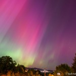 Curtains of pink and green lights fill the night sky